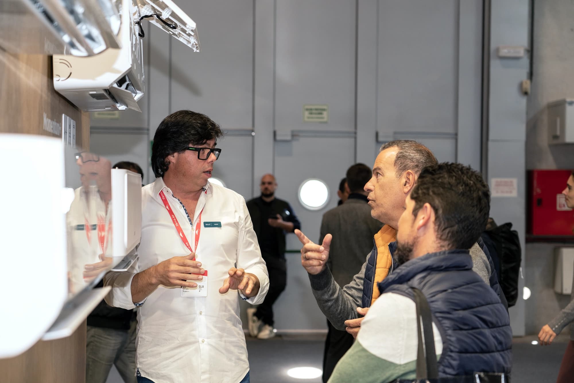 Een BAUF-specialist legt installateurs op een beursstand de techniek uit