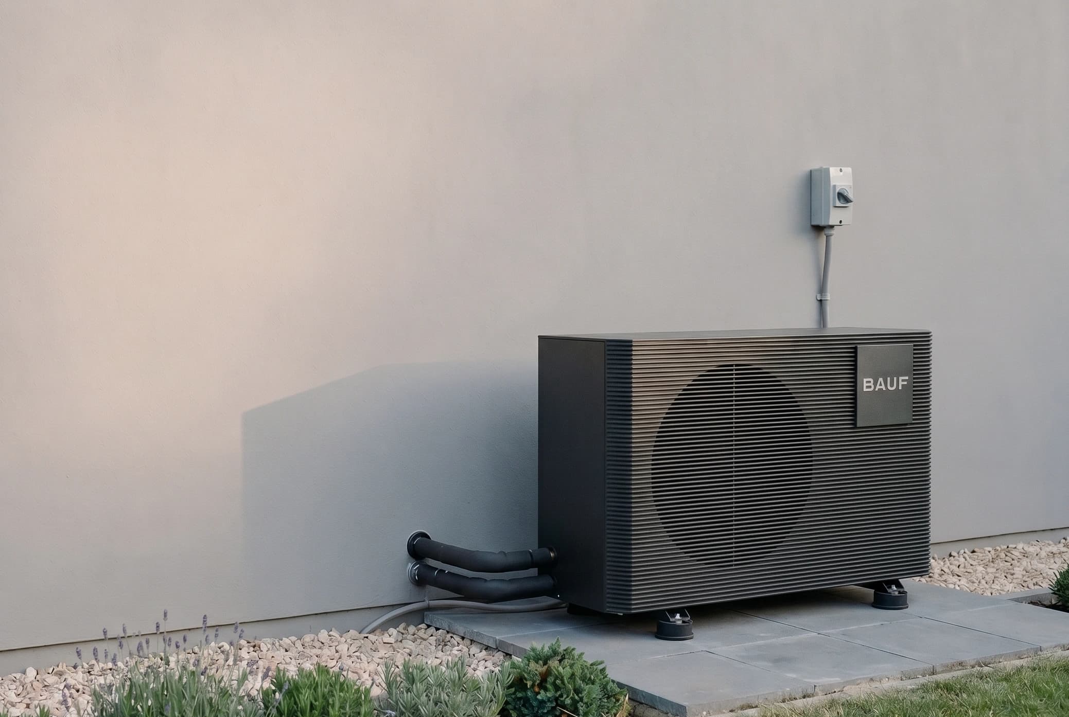 Hamme monoblock-warmtepomp op wandbeugels aan de buitenkant van een woning